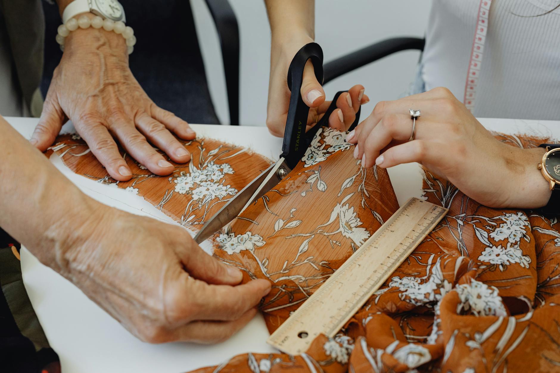 Dwie osoby wycinają materiał w pracowni krawieckiej