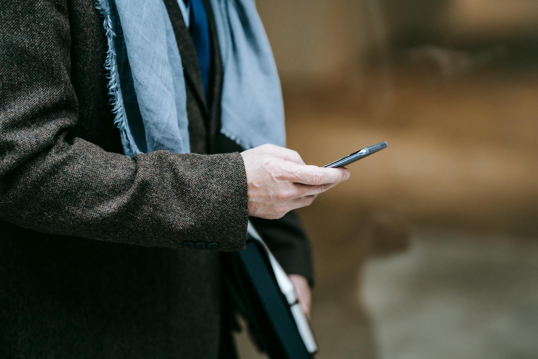 Elegancka osoba na zewnątrz korzysta ze smartfona