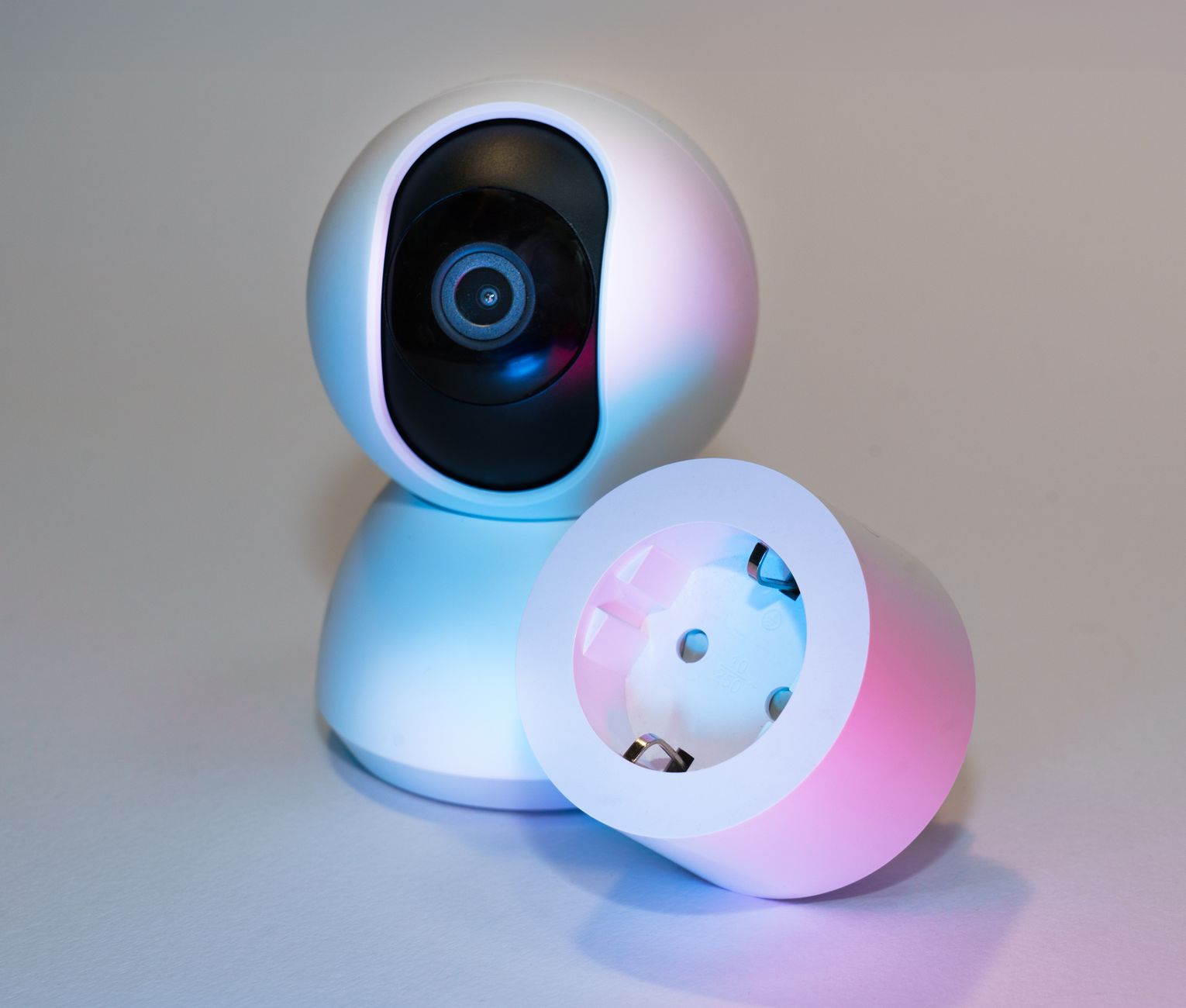 Kamera smart home i gniazdko elektryczne na jasnym tle