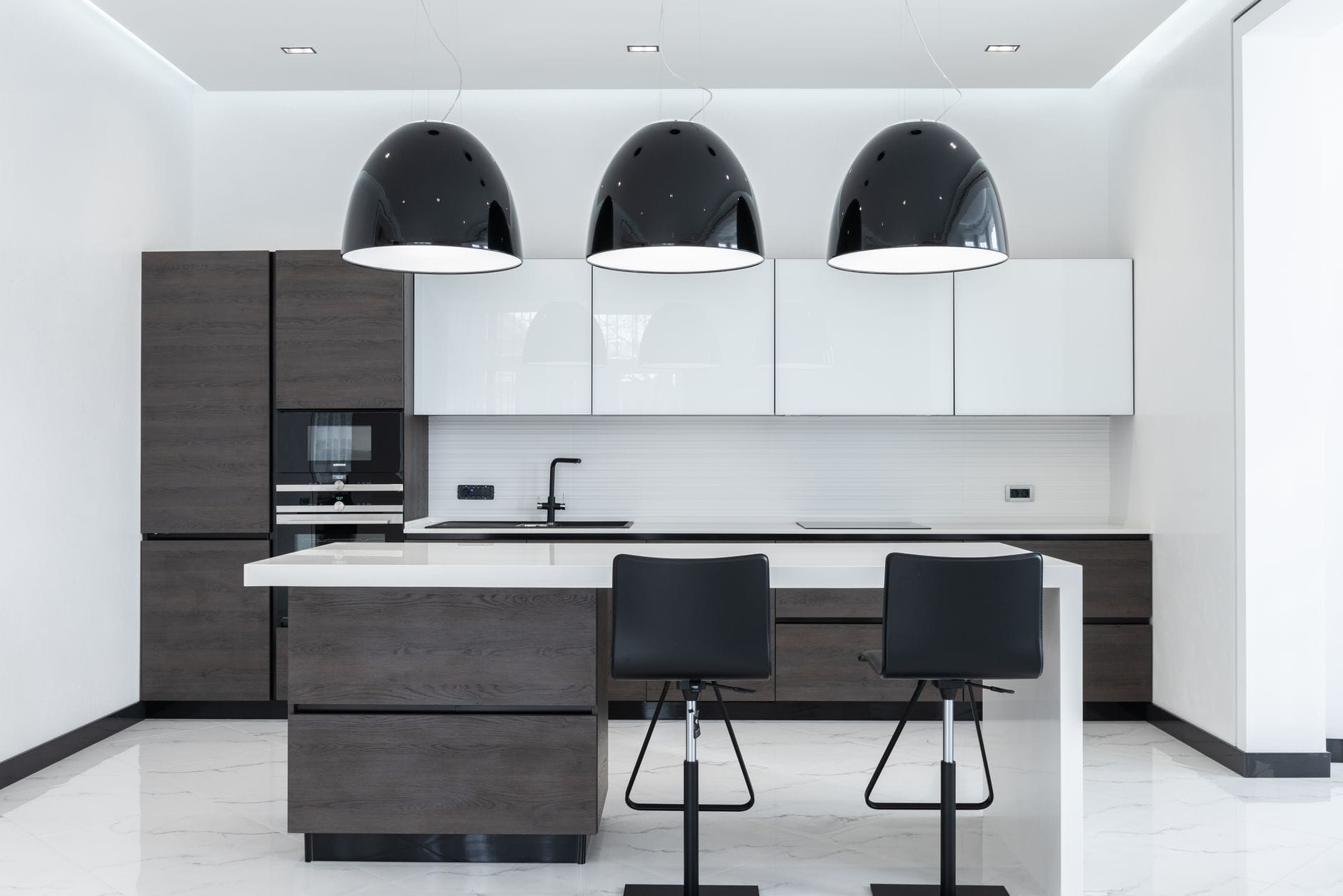 Nowoczesna kuchnia z wyspą i designerskimi lampami nad stołem