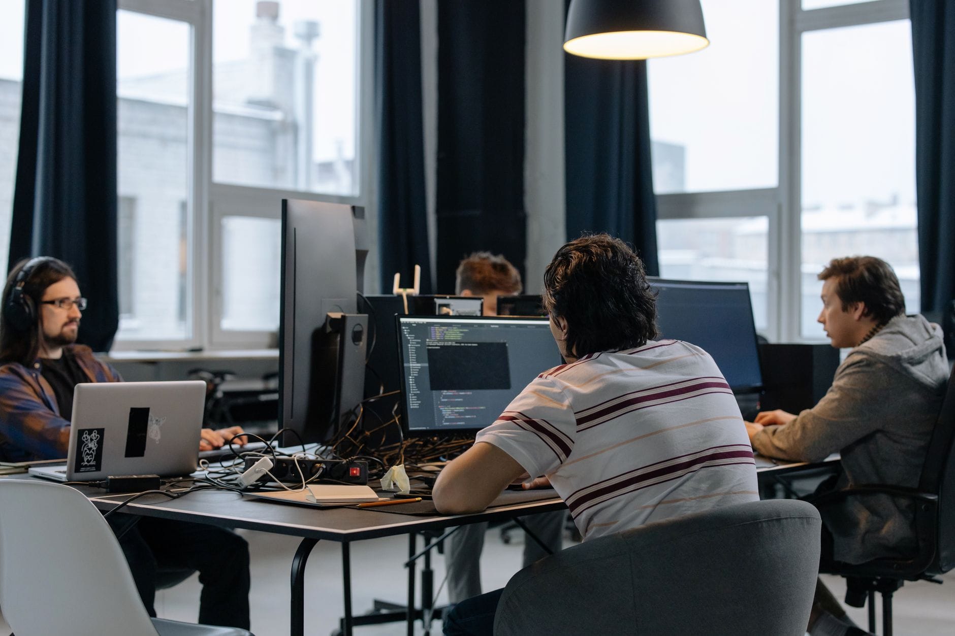 Zespół programistów pracuje przy komputerach w nowoczesnym biurze IT
