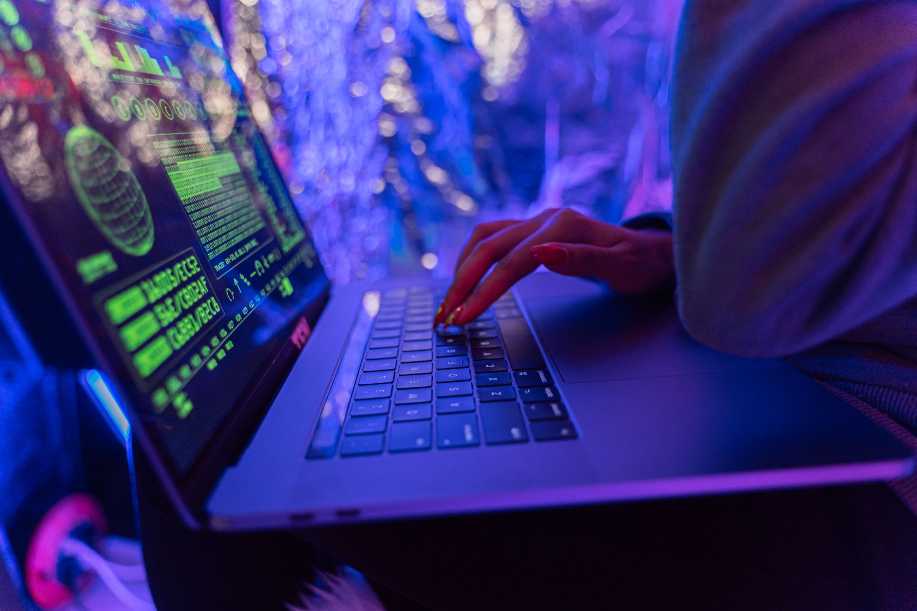 Dłonie piszące na laptopie z grafikami cyberbezpieczeństwa